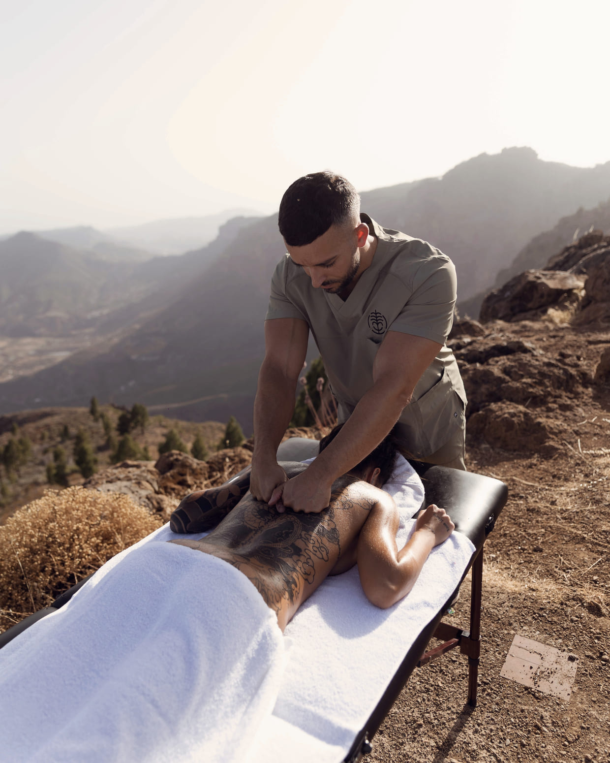 Sharel Martínez aplicando terapia manual en un mirador de Gran Canaria, con el valle al fondo