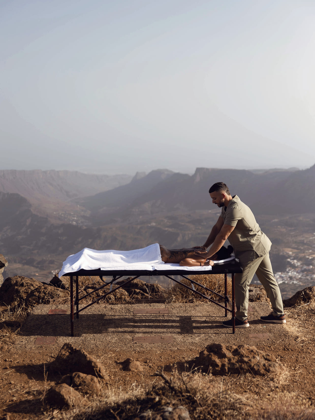 Sesión de bienestar al aire libre sobre una cresta volcánica de Gran Canaria, con la cordillera al fondo
